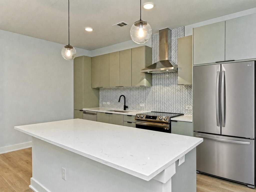 Kitchen with stainless steel electric stove, wall chimney exhaust hood, a sink, gray cabinetry, and light laminate flooring